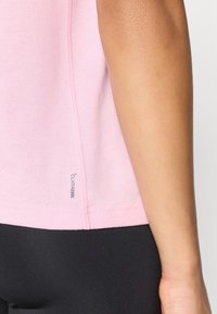 Αθλητική μπλούζα σε ανοιχτό ροζ χρώμα με υφή και σχεδιασμό που επιτρέπει την αναπνοή. Διαθέτει το λογότυπο ClimaCool κοντά στο τελείωμα, συνδυασμένη με μαύρο κολάν.