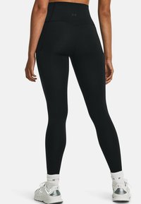 Hoge taille zwarte leggings van rekbare stof, met een slank ontwerp en een gladde textuur. Voorzien van zijzakken voor extra gemak.
