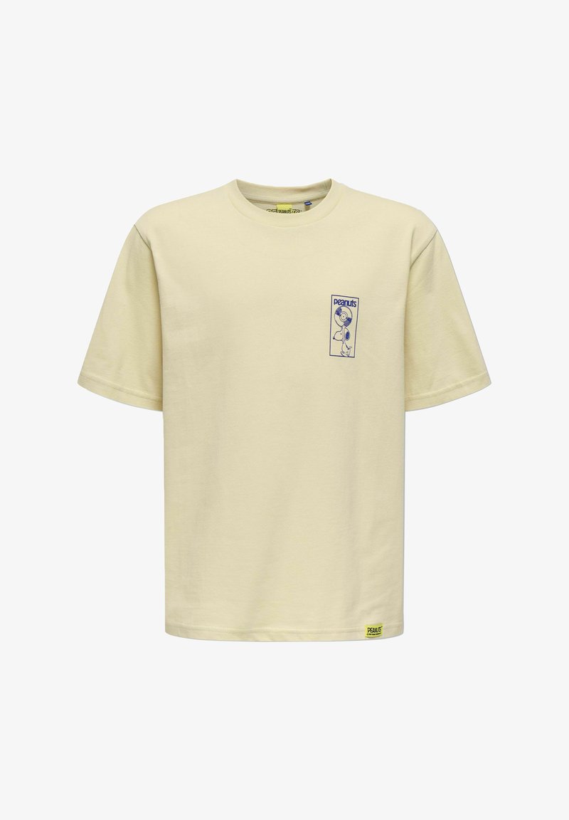 T-shirt beige à manches courtes avec une petite illustration bleue de Snoopy et le texte « peanuts » sur le côté gauche de la poitrine, ainsi qu'une étiquette jaune Peanuts près de l'ourlet.