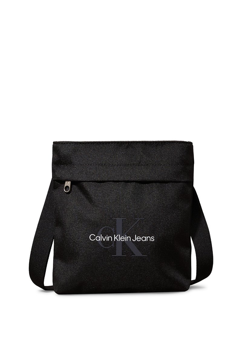 Sort stof skuldertas med lynlåslukning. Har et fladt design og trykt "Calvin Klein Jeans" logo i hvid og grå.