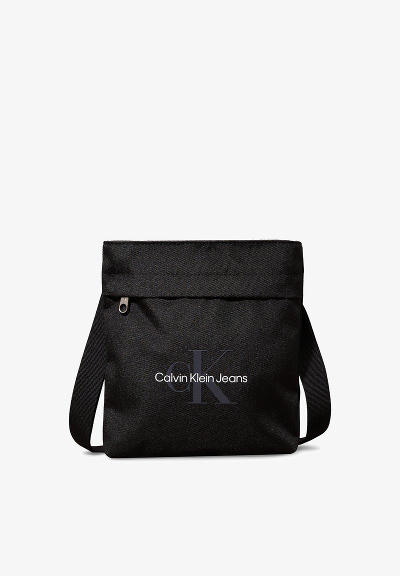 Black fabric shoulder bag with zipper closure. Features a flat design and printed "Calvin Klein Jeans" logo in white and gray.