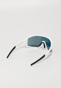 Weiße Sportsonnenbrille mit schwarzen Griffen, einzelner blau getönter Linse und Logo auf den Seitenarmen vor einem weißen Hintergrund.