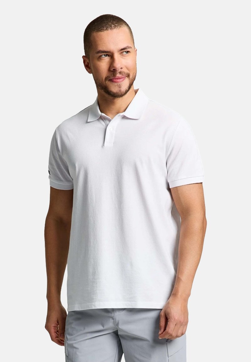 Polo shirt blanc en tissu texturé, avec un col classique et des manches courtes. Pas d'ornements ni de motifs visibles.
