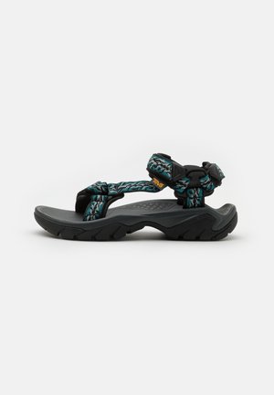 Black sandals with woven teal and black straps, adjustable buckle, and textured gray sole. Designed for durability and comfort.