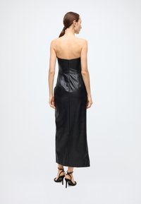 Black leather strapless maxi dress with a fitted bodice and back zipper, smooth texture, and a floor-length silhouette.
