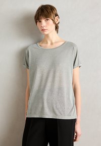 Shirt met korte mouwen in lichtgrijs met een subtiele glans. Heeft een ronde halslijn en een klein metallic logo-detail aan de zoom.