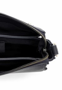 Czarna skórzana torebka na ramię ze złotym zamkiem, wyposażona w przestronne wnętrze wyłożone tkaniną oraz liczne przegródki ułatwiające organizację.