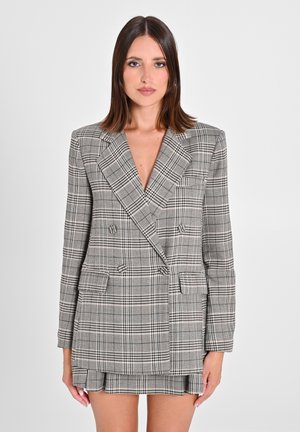 Grau karierter, doppelt geknöpfter Blazer mit breiten Revers, Schulterpolstern und zwei vorderen Taschen; kombiniert mit einem passenden Rock.