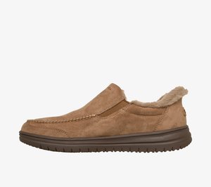 Sapatos castanhos de camurça tipo slip-on com forro de pêlo suave, painéis laterais elásticos e sola de borracha texturizada. Detalhes com costura na parte superior.