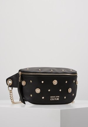 Czarna skórzana saszetka na pas z złotymi ćwiekami i dekoracyjnymi kwiatowymi akcentami, złoty suwak oraz logo „Versace Jeans Couture” z przodu.