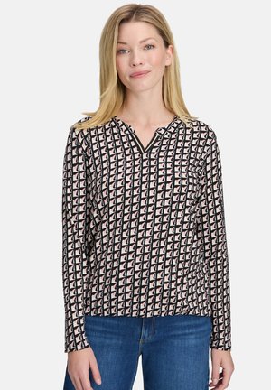 Blusa a maniche lunghe in nero, crema e rosa con un motivo geometrico, scollatura a V e tessuto morbido dalla superficie liscia.