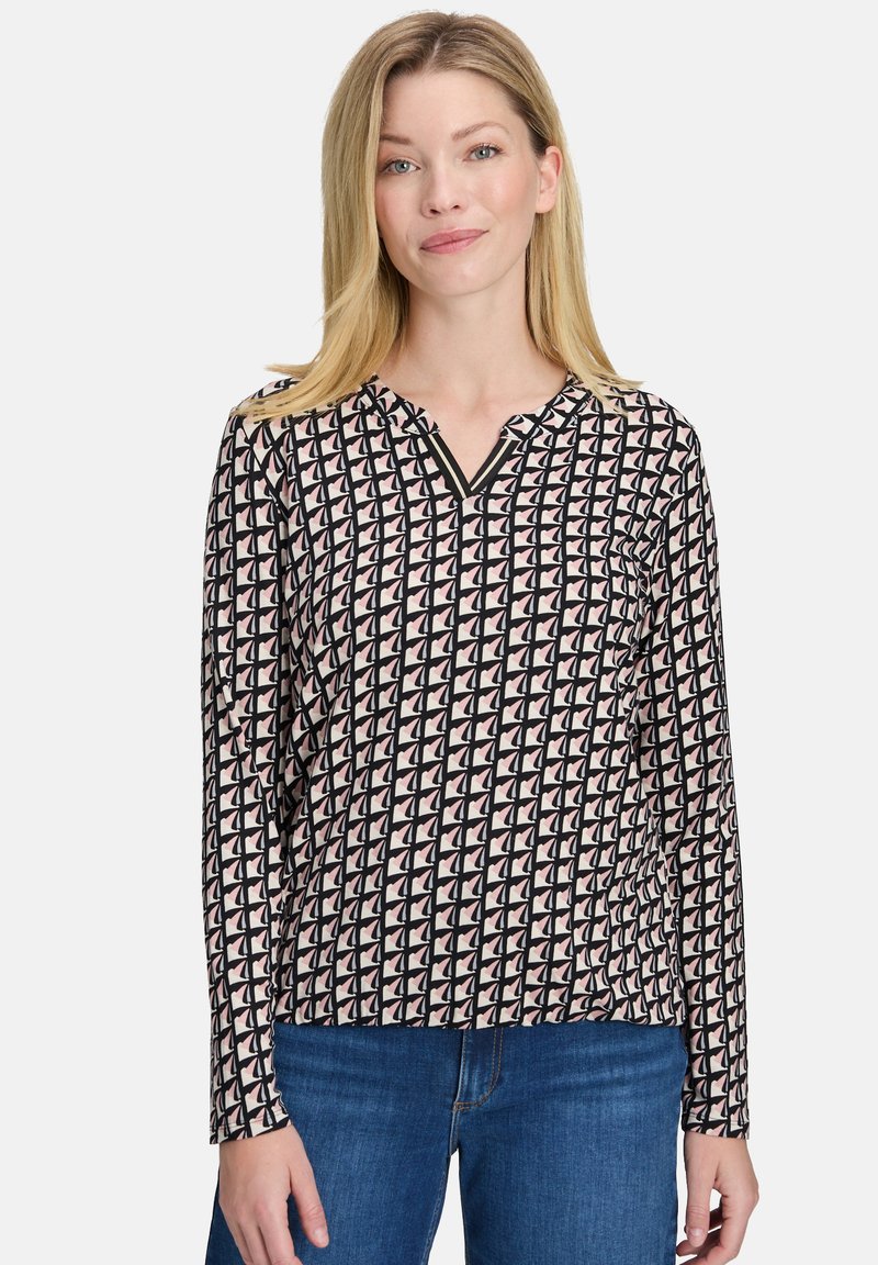 Bluzka z długim rękawem w kolorze czarnym, kremowym i różowym, z geometrycznym wzorem, dekoltem w kształcie V oraz miękkiego materiału o gładkiej teksturze.