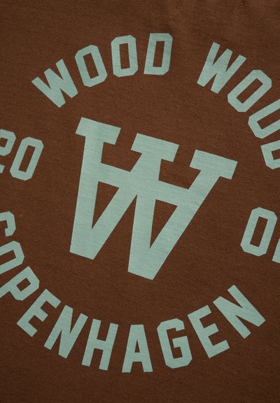 Tessuto marrone con grande testo turchese che dice "WOOD WOOD" e "COPENHAGEN", con un logo prominente al centro.
