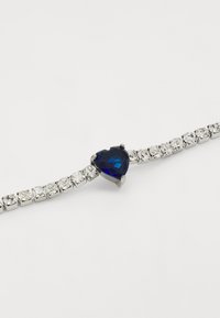 Bracciale in argento con una pietra blu a forma di cuore al centro, circondata da pietre trasparenti rettangolari e rotonde, con una finitura lucida.
