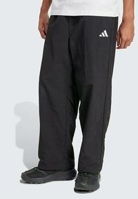 Kergedest kootud mustad püksid elastse vöökohaga. Omavad kolme valget triipu ja Adidas'i logo vasakul reiel.