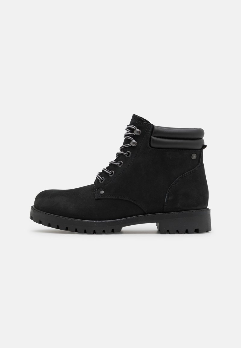Stivaletti neri in suede alla caviglia con punta arrotondata, suola in gomma nera e lacci grigi. Presentano un colletto imbottito per un maggiore comfort.