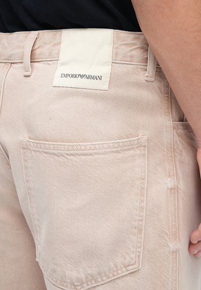 Ροζ τζιν παντελόνι με μεγάλο πίσω τσέπη, ετικέτα υφάσματος με την επιγραφή «Emporio Armani» και υφή στο υλικό.