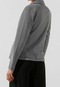 Veste à motifs noir et blanc avec col, coupe slim, tissu texturé et manches longues, vue de dos.