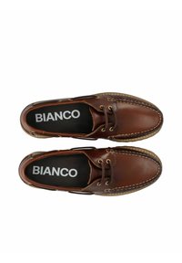 Braune Lederbootsschuhe mit beiger Naht, Schnürung um den Kragen und schwarzen Innensohlen mit dem "BIANCO"-Logo. Flache Sohlenkonstruktion.