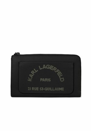 Schwarze Reißverschlusstasche mit vordere Tasche mit "Karl Lagerfeld Paris 21 Rue St-Guillaume" Text in gepunkteter Schrift.