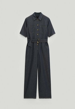 Combinaison en denim à manches courtes, avec deux poches poitrine et une taille ceinturée. Tissu bleu foncé à texture lisse et coupe droite.
