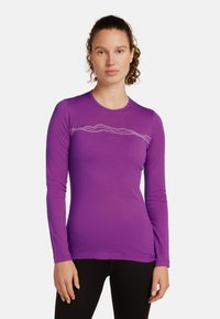 Camicia a maniche lunghe di colore viola realizzata in tessuto leggero, caratterizzata da un sottile motivo a onde bianche sul petto e un collo arrotondato.