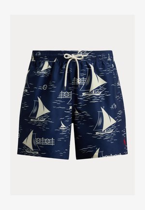 Marineblauwe zwembroek met witte zeilboot- en oceaangolfpatronen, elastische tailleband, witte aantrekkoord en rood logo nabij zoom.