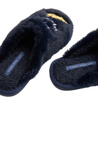 Zapatillas de felpa azul marino con textura suave, diseño superior abierto y suela de goma. Cuenta con un estampado bordado en amarillo y blanco. Etiqueta de talla visible.