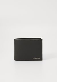 Svart läderplånbok med en slät yta, vikdesign med två fickor och minimalistisk sömnad. Framträdande logga i guldmetall på framsidan.