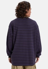 Paars en zwarte gestreepte langembe shirt, gemaakt van zachte stof met een relaxte pasvorm en ribgebreide manchetten, met een eenvoudig ontwerp en een ronde zoom.
