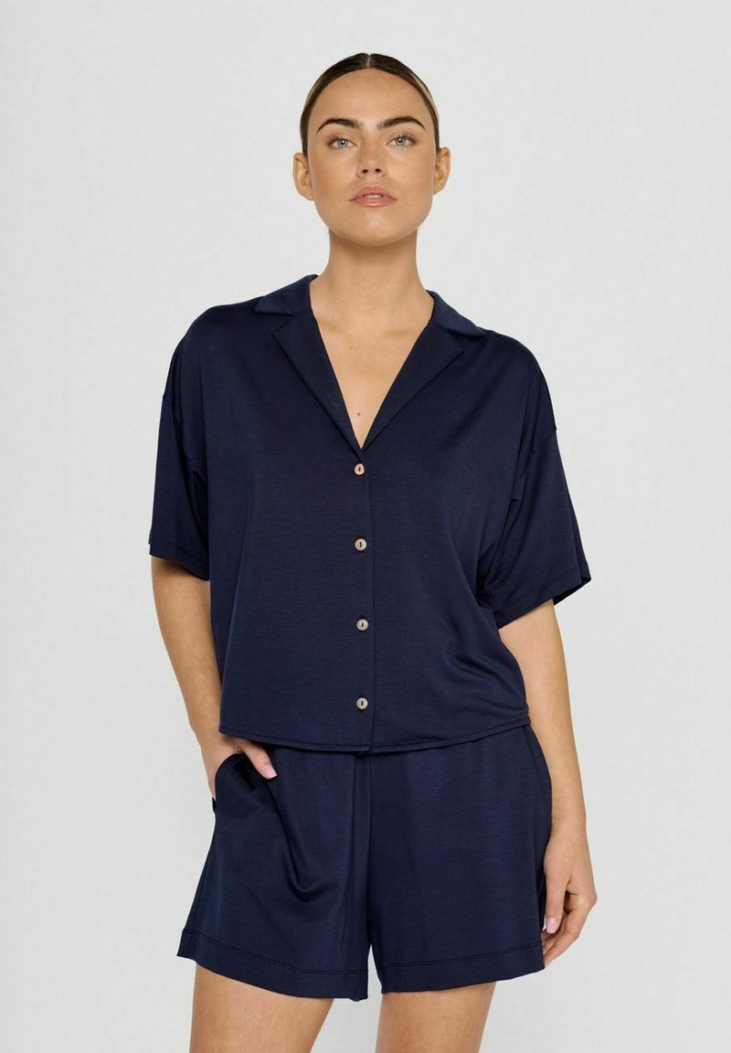 Navy-blaues Loungewear-Set, das ein kurzärmliges, knöpfbares Oberteil mit Kragen und passende Shorts mit elastischem Bund umfasst. Glatte Textur.