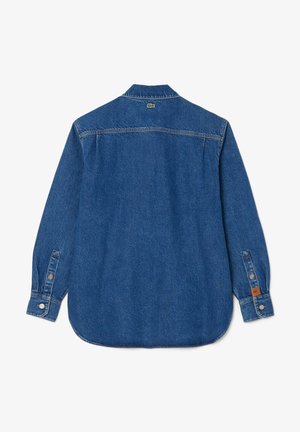 Denim srajca v temno modri barvi, z dolgimi rokavi, gumbi na manšetah in zaobljenim robom. Lacoste logo na hrbtni strani blizu ovratnika.