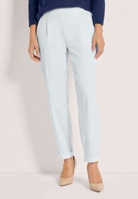 Lichtblauwe op maat gemaakte broeken met voorvouwen, omslagbodems en een soepele textuur, gecombineerd met beige puntige hakken.