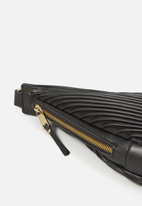 Clutch bag in pelle nera con texture rigata e hardware della cerniera dorato. Presenta una forma snella e una tracolla removibile per maggiore versatilità.