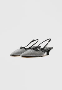 Black and silver open-toe slingback heels with pointed toes, rhinestone detailing, adjustable straps, and a low, block heel.