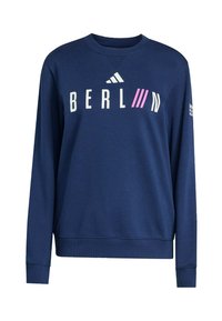 Felpa a maniche lunghe blu navy con testo "BERLIN", strisce diagonali rosa e logo Adidas sul petto, e testo bianco sulla manica destra.