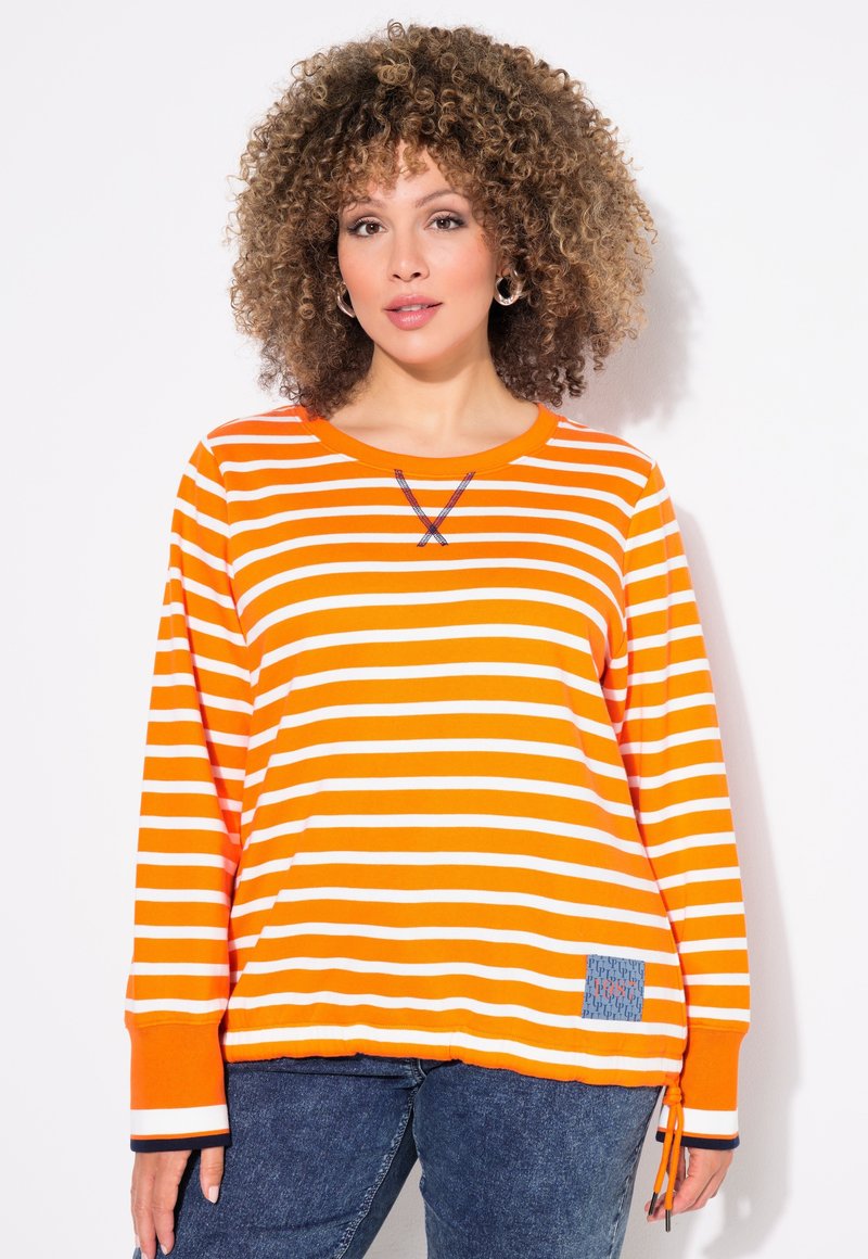 Oranje en witte gestreepte langemouwen shirt met een ronde halslijn, met een kruissteekdetail bij de hals en een blauwe patroonpatch.