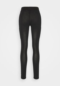 Svarta leggings i stretchy tyg, med hög midja och två sidofickor, med en slät yta och figurnära design.