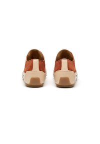 Chaussures à enfiler en suède marron avec une semelle en caoutchouc crème, présentant une texture lisse et un design de couleur contrastante au niveau du talon.