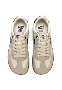 Zapatillas beige con parte superior de cuero suave y acentos de ante. Presenta una suela texturizada, cierre de cordones con seis ojales y detalle del logo.