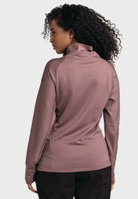 Langarm-Oberteil mit hohem Kragen in Mauve, mit gerippter Textur und seitlichen Schlitzen. Verfügt über eine figurbetonte Passform und einen weichen Stoff für zusätzlichen Komfort.