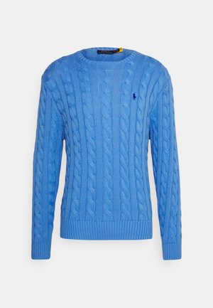 Pull bleu en maille torsadée, col rond, manches longues, avec un petit logo brodé bleu foncé sur le côté gauche de la poitrine.