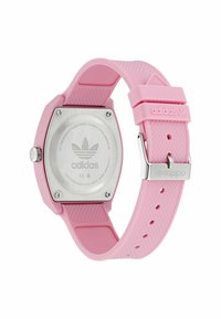 Montre en silicone rose avec un boîtier hexagonal et un dos en acier inoxydable. Dotée d'un bracelet texturé et d'une boucle argentée. Logo Adidas sur le boîtier et le bracelet.