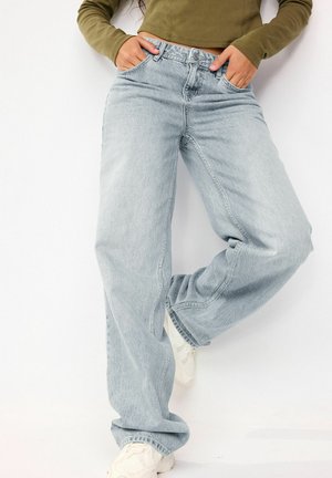 Lichtblauwe, wijde-jeans gemaakt van denim, met voorzakken en een klassieke knoopsluiting. Gestyled met een cropped olijfgroene top.