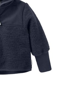 Marineblauer Fleece-Pullover mit einem glatten, kontrastierenden Panel, gerippten Ärmeln und Saum. Weiche Textur mit einem gestickten Etikett am unteren Rand.