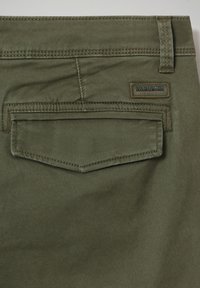 Olijfgroene katoenen broek met een achterzak voorzien van een gelaagde, hellende klep en een gebrandmerkte label op de stof genaaid.
