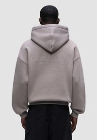 Felpa grigia oversized con cappuccio, con un logo testurizzato sul retro, polsini e orlo a costine, realizzata in un tessuto morbido.