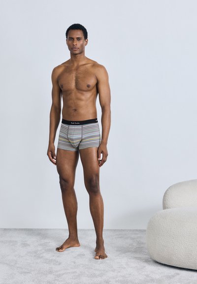 Boxers rayés pour hommes avec une ceinture noire. Le tissu présente des lignes horizontales de différentes couleurs sur un fond clair.