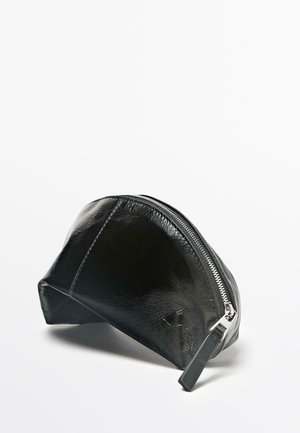 Zwarte pouch van synthetisch leer met een afgeronde vorm en een gestructureerd oppervlak. Voorzien van een zilverkleurige rits aan de bovenkant voor sluiting.