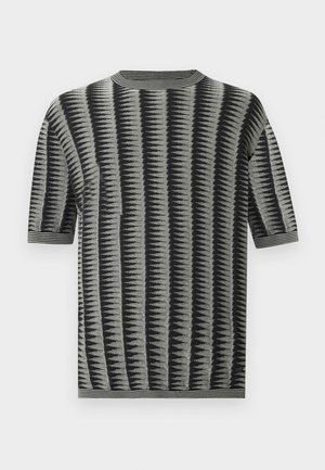 Kortermet strikket topp i grått med svarte sikksakkstriper. Har en ribbestrikket rund hals og et teksturert stoff med en jevn overflate.